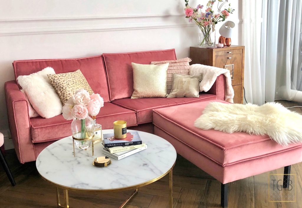 roze bank met salontafel en decoratie
