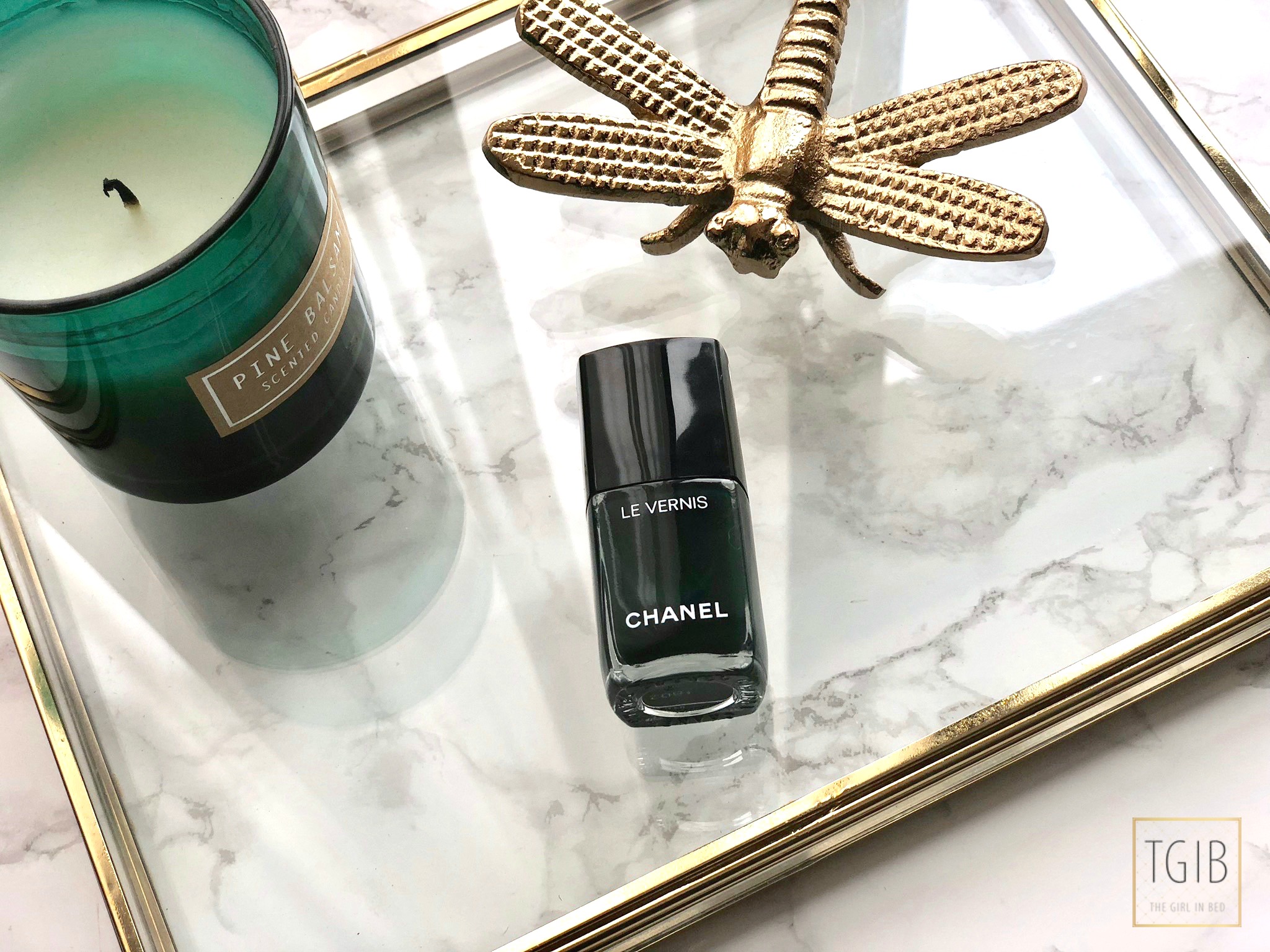 Chanel nail polish with ornament and a green candle